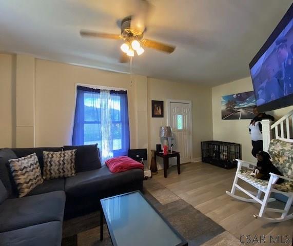 living room with hardwood / wood-style floors and ceiling fan