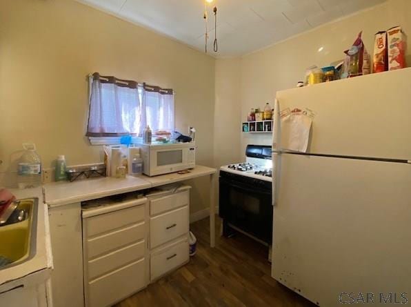 kitchen with dark wood-type flooring, sink, white cabinets, and white appliances