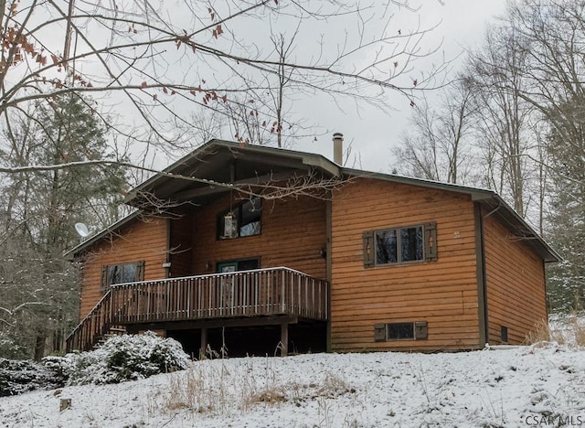 snow covered house with a deck