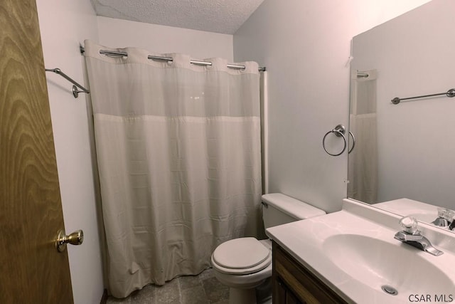 bathroom with vanity, toilet, and a textured ceiling