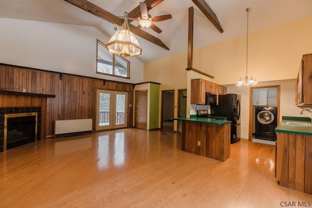 kitchen with sink, radiator, an inviting chandelier, black appliances, and washer / dryer