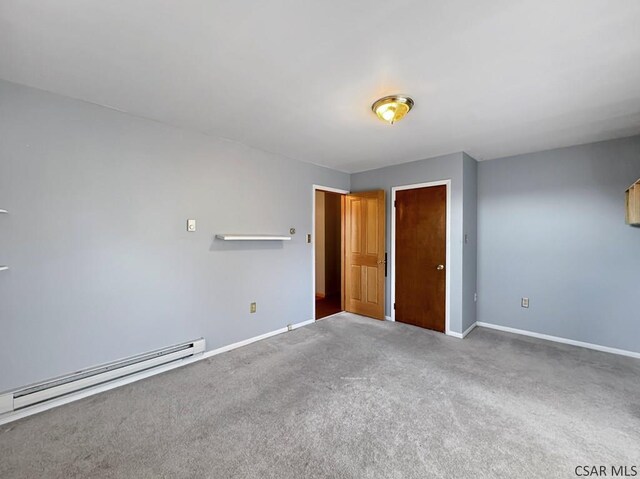 empty room with baseboard heating and carpet