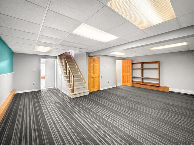 basement with dark carpet and a drop ceiling