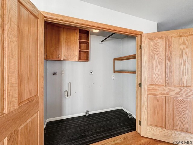 clothes washing area with hardwood / wood-style flooring, hookup for an electric dryer, and hookup for a washing machine