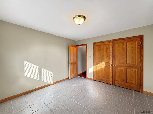 unfurnished bedroom with light tile patterned floors and a closet