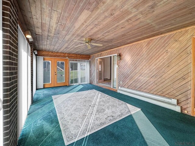 unfurnished sunroom featuring a baseboard radiator, wooden ceiling, ceiling fan, and french doors