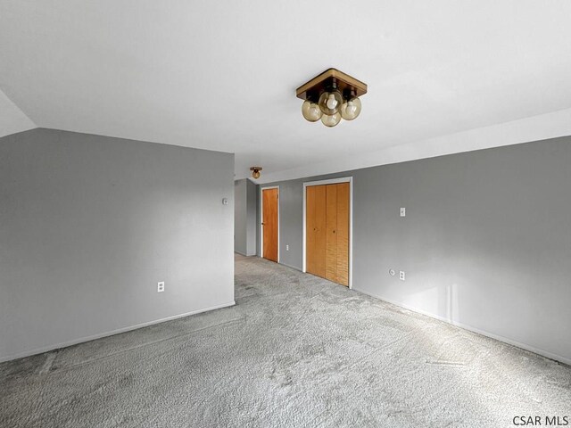 empty room with carpet flooring and vaulted ceiling