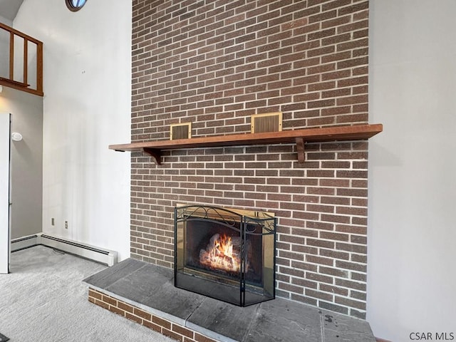 room details with a brick fireplace, a baseboard radiator, and carpet