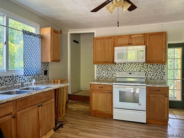 kitchen with sink, tasteful backsplash, light wood-type flooring, ornamental molding, and white appliances