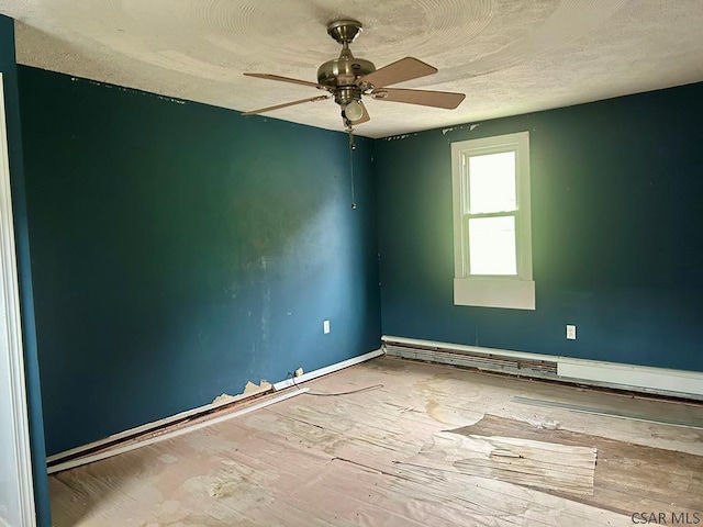 empty room featuring ceiling fan and baseboard heating