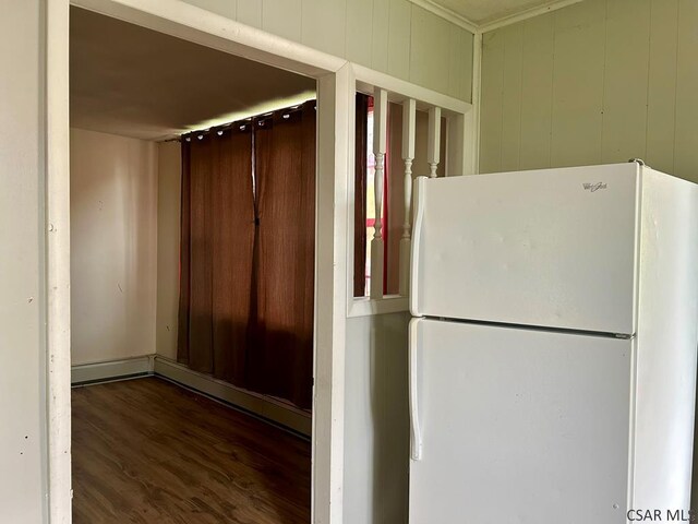 kitchen featuring white refrigerator, dark hardwood / wood-style flooring, and wood walls