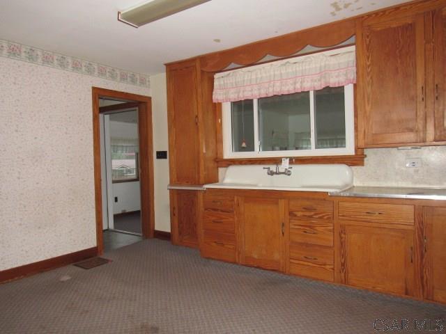 619 W Race St, Somerset, PA 15501 - kitchen featuring carpet flooring, brown cabinets, wallpapered walls, baseboards, and light countertops