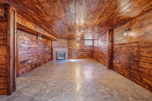 unfurnished living room with wood walls, a brick fireplace, and wooden ceiling