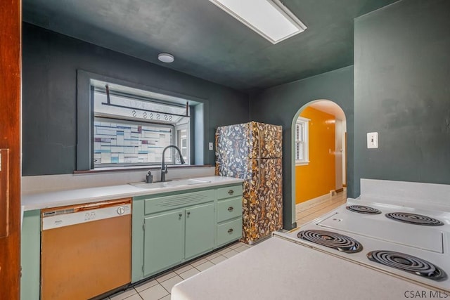 kitchen featuring light countertops, green cabinets, light tile patterned flooring, a sink, and dishwasher