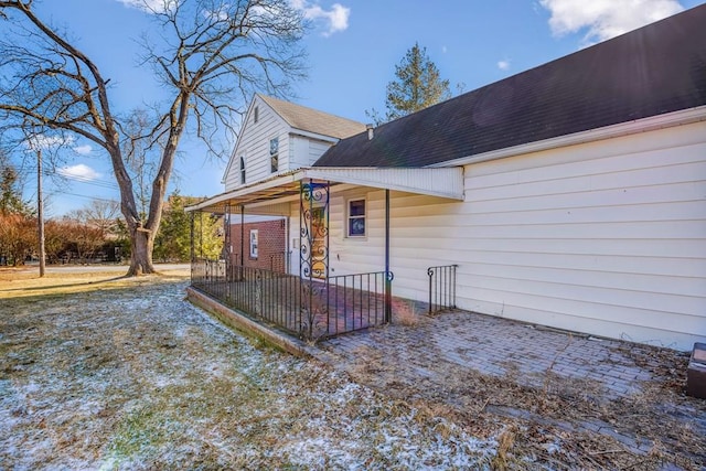 exterior space with a shingled roof and a porch