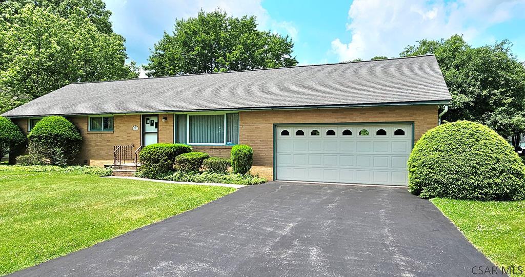 136 Martha Ln, Johnstown, PA 15905 - ranch-style home with asphalt driveway, brick siding, a front yard, an attached garage, and roof with shingles