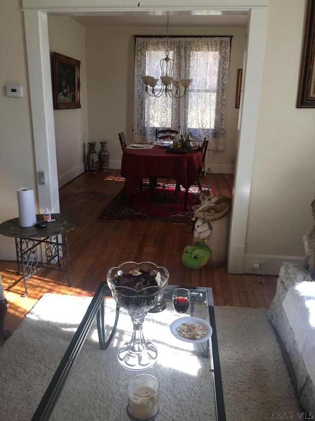 dining area featuring hardwood / wood-style floors and an inviting chandelier