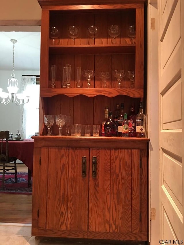 bar with a chandelier and decorative light fixtures