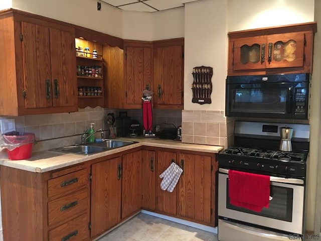 kitchen featuring stainless steel gas stove, sink, and tasteful backsplash