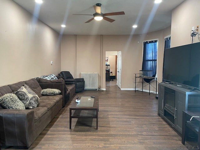 living area with dark wood-type flooring, radiator heating unit, recessed lighting, and baseboards