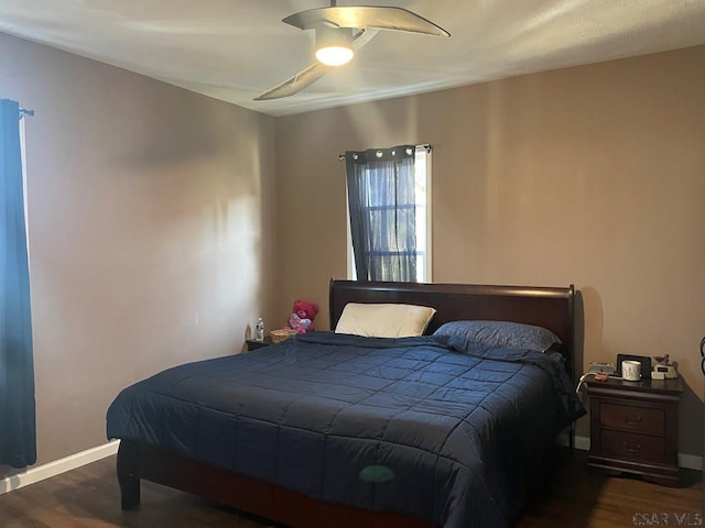 bedroom with ceiling fan, baseboards, and wood finished floors