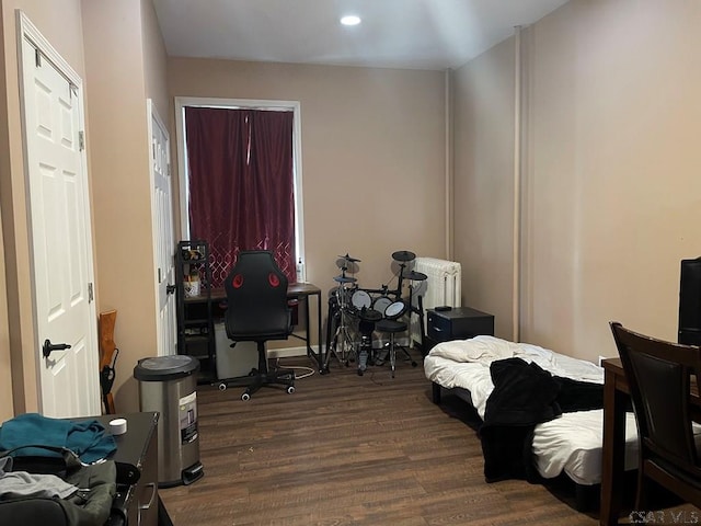 bedroom with radiator heating unit, dark wood-style floors, and recessed lighting