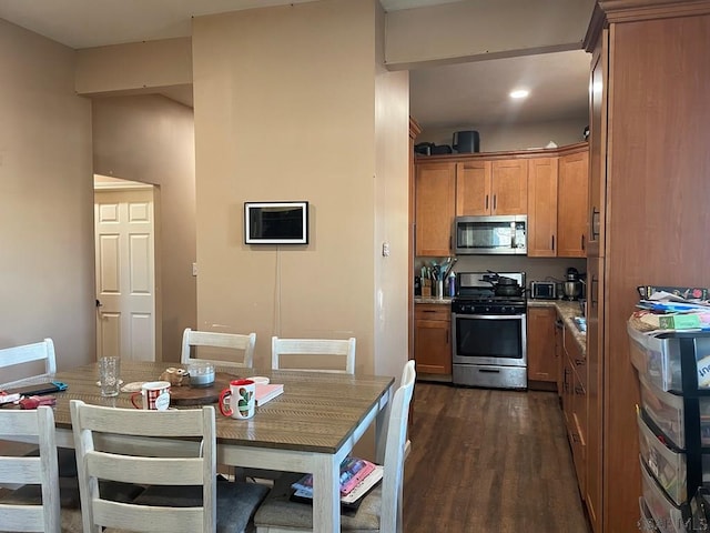 kitchen featuring brown cabinetry, dark wood finished floors, and appliances with stainless steel finishes