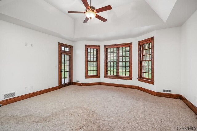 unfurnished room featuring carpet, ceiling fan, and a tray ceiling