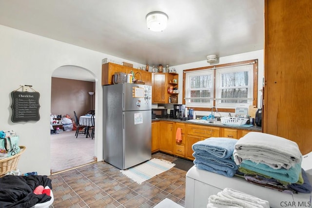 kitchen with stainless steel fridge, sink, and dark colored carpet