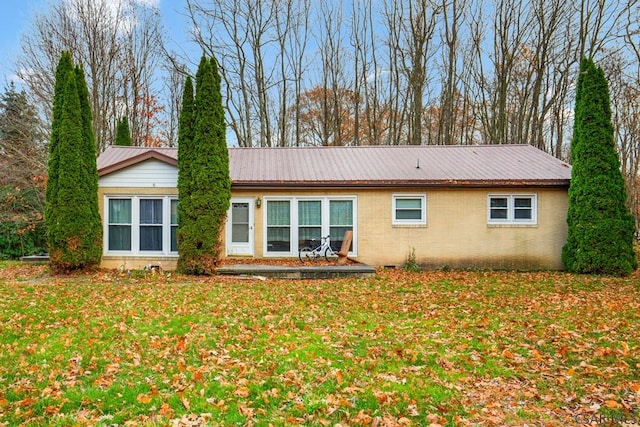 rear view of property with a lawn