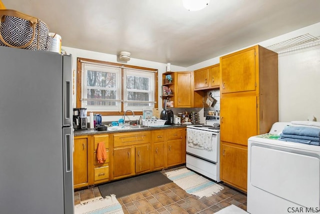 kitchen with washer / clothes dryer, sink, electric range, and stainless steel refrigerator