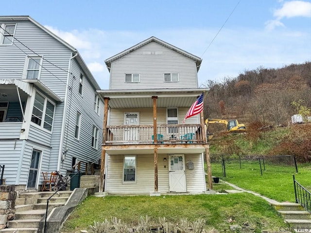 view of front of house with a front yard and a balcony