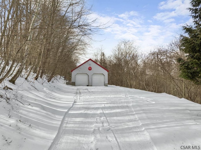 snow covered structure with a garage