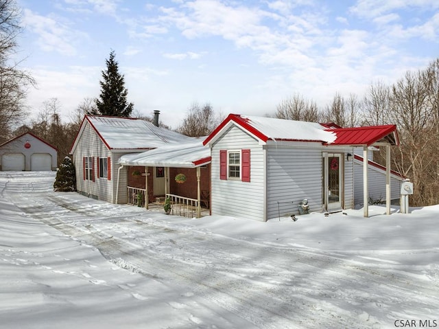 view of front of property featuring a garage, an outdoor structure, and a porch