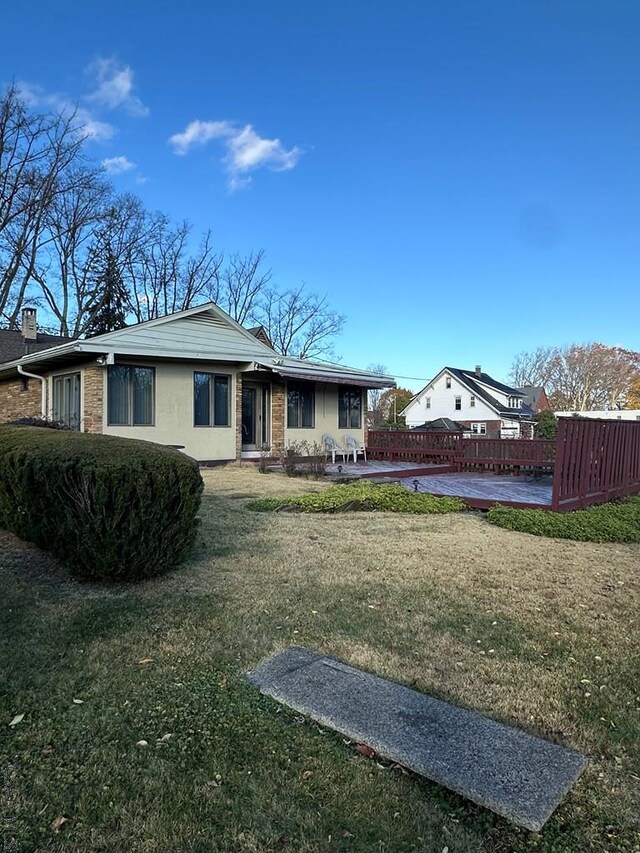 back of property with a yard and a deck