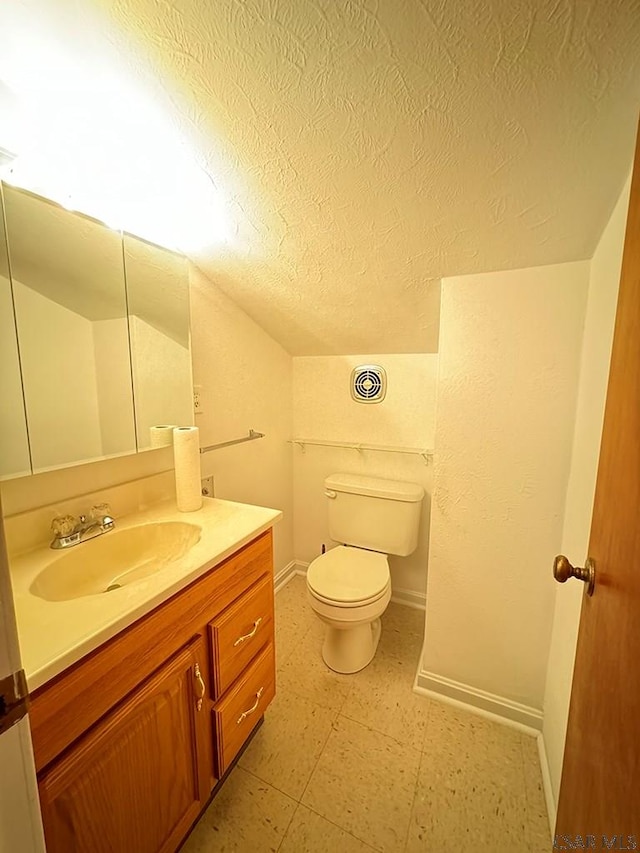 bathroom with lofted ceiling, toilet, a textured ceiling, and vanity