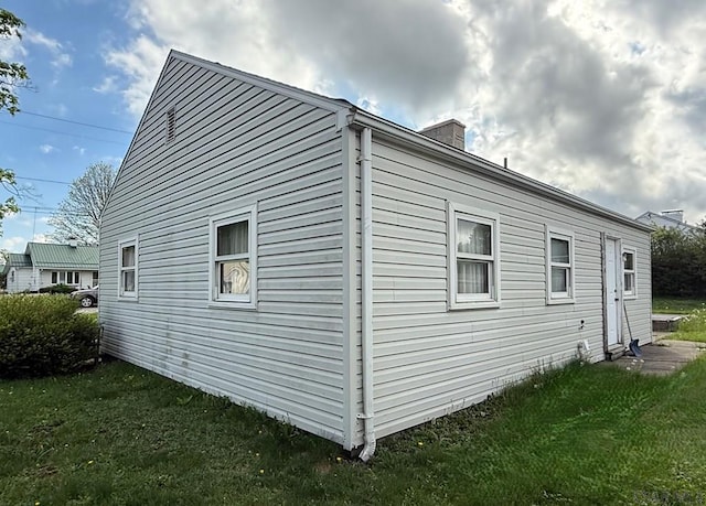 view of home's exterior featuring a yard and a chimney