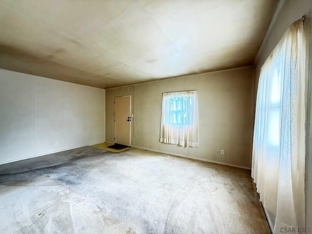 spare room featuring carpet flooring and baseboards
