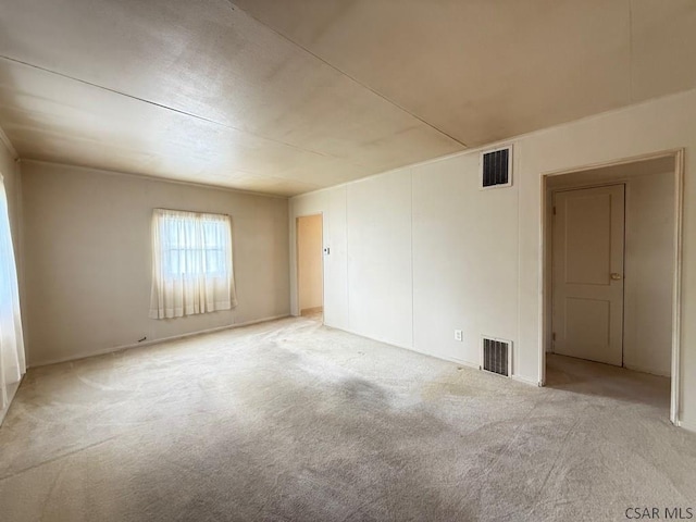 unfurnished room featuring light colored carpet and visible vents