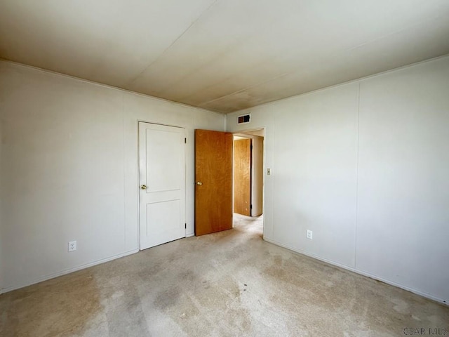 carpeted empty room featuring visible vents