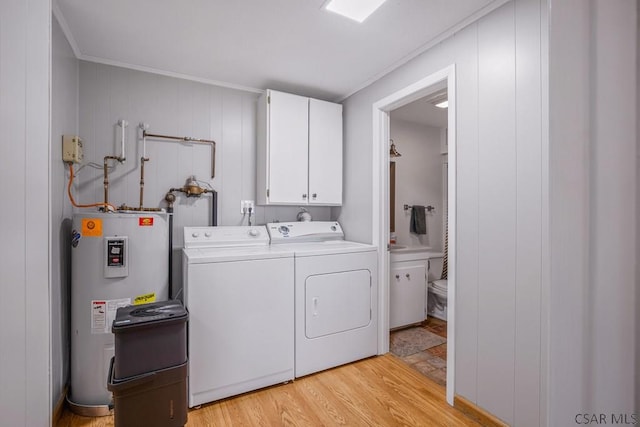 218 Rocky Ridge Rd, Jennerstown, PA 15547 - washroom featuring washing machine and dryer, light wood-style flooring, water heater, and cabinet space