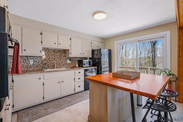 218 Rocky Ridge Rd, Jennerstown, PA 15547 - kitchen featuring light countertops, a sink, decorative backsplash, black appliances, and white cabinetry