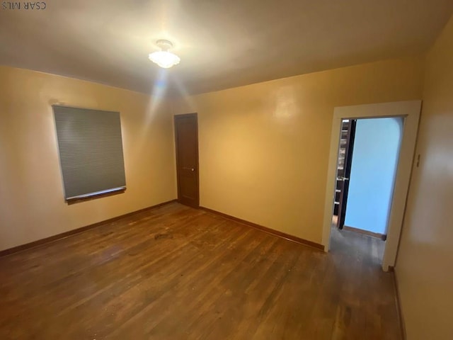 spare room featuring wood finished floors and baseboards