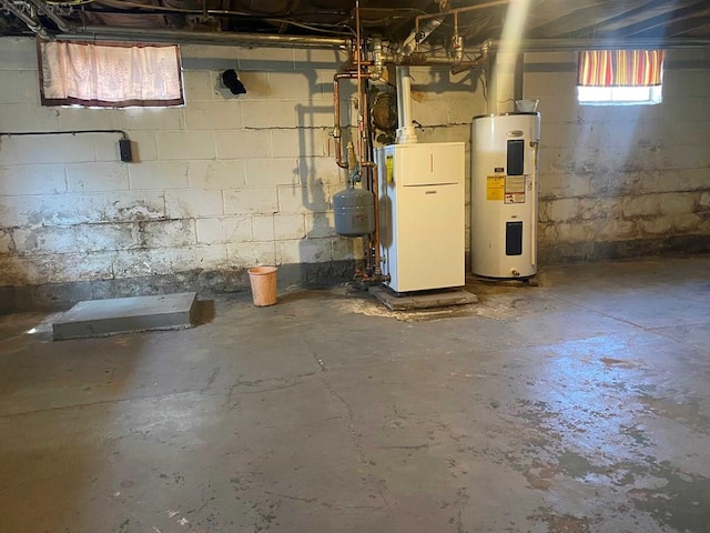 basement featuring electric water heater and water heater