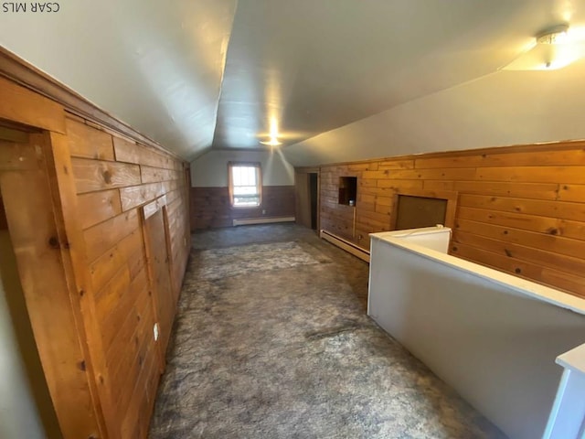 additional living space with a wainscoted wall, a baseboard heating unit, wooden walls, carpet flooring, and vaulted ceiling