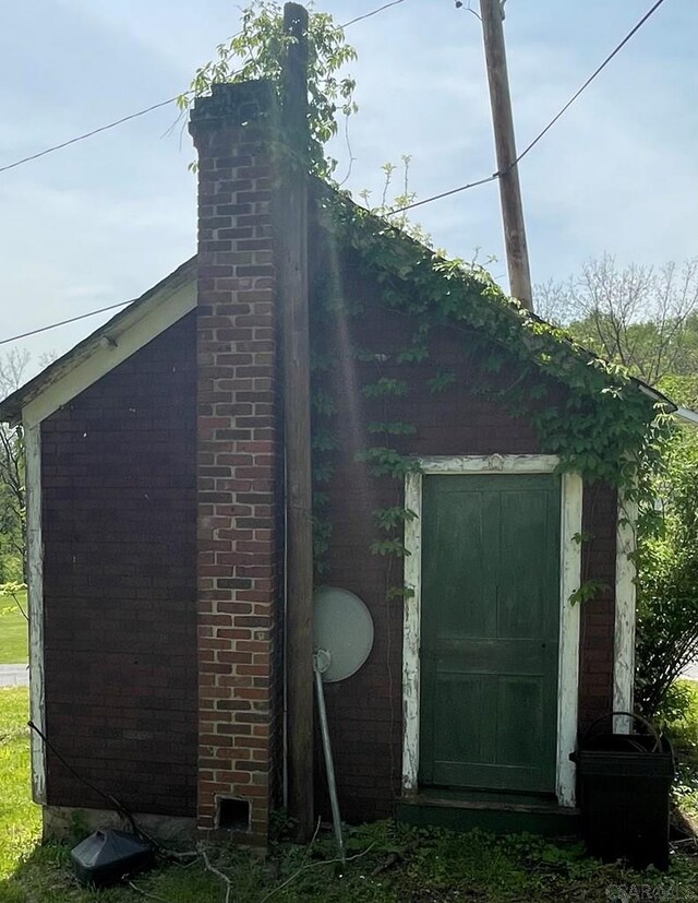 424 W Main St, Stoystown, PA 15563 - view of property exterior with an outbuilding, brick siding, and a chimney