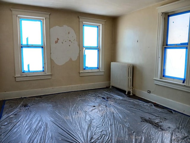 spare room featuring radiator and a wealth of natural light