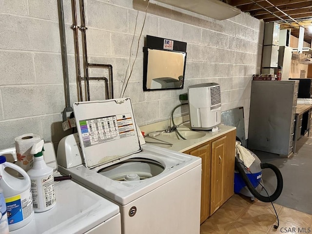 laundry room with separate washer and dryer, sink, and cabinets