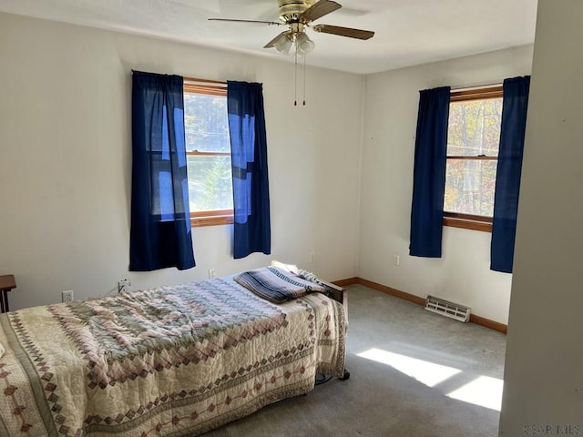 carpeted bedroom featuring ceiling fan and multiple windows