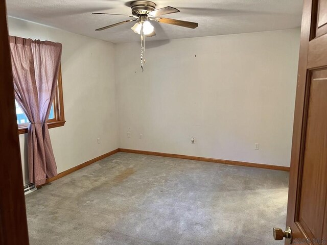 spare room with ceiling fan and light colored carpet